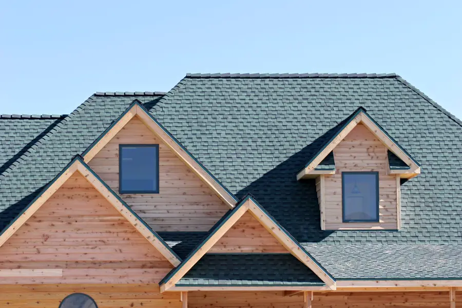 Green shingle roof with cedar-faced dormers