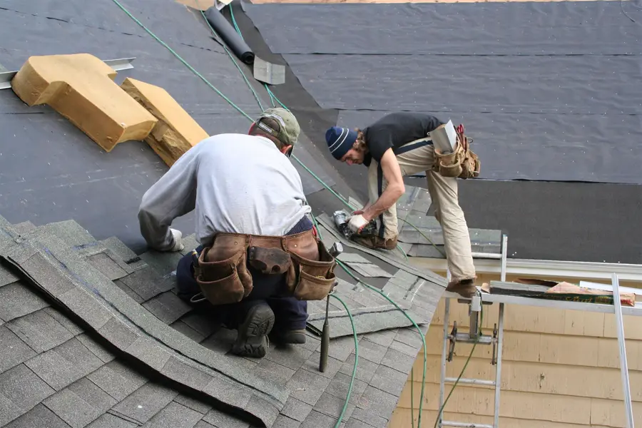 Two roofers working on a pitched roof